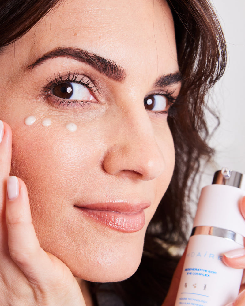 Woman applying eye cream from Brightening Trio to under eye area with focus on hydration gallery position 1