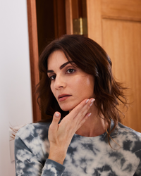 Woman gently touching her cheek demonstrating skincare with Vitamin C-FK  Brightening Complex in gallery position 1